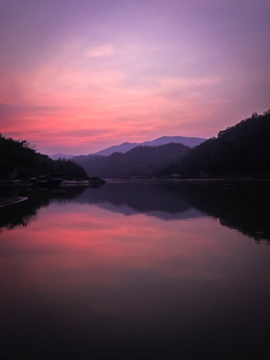 Serene sunset view with vibrant colors reflecting on a calm river in Laos.